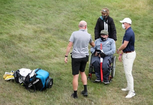 Nick Pugh, caddie of Lucas Herbert of Australia hands over some memorabilia to a disabled fan during Day Three of The Dubai Duty Free Irish Open at...