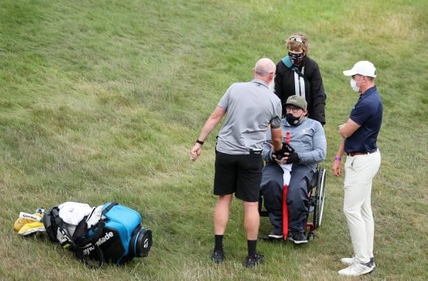Nick Pugh, caddie of Lucas Herbert of Australia hands over some memorabilia to a disabled fan during Day Three of The Dubai Duty Free Irish Open at...