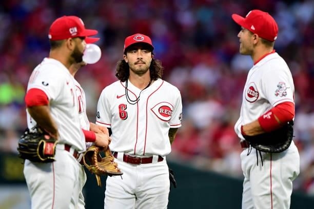 Jonathan India of the Cincinnati Reds talks to Joey Votto, Kyle Farmer and Eugenio Suarez during a game between the Chicago Cubs and Cincinnati Reds...
