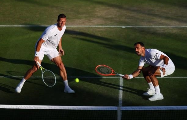 Filip Polasek of Slovakia and Ivan Dodig of Croatia compete for the ball during their men's doubles second round match against Cameron Norrie of...