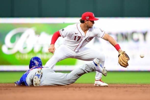 Kyle Farmer of the Cincinnati Reds attempts to make a catch as Willson Contreras of the Chicago Cubs slides into second base during a game at Great...
