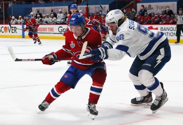 Mikhail Sergachev of the Tampa Bay Lightning checks Cole Caufield of the Montreal Canadiens during Game Three of the 2021 NHL Stanley Cup Final at...