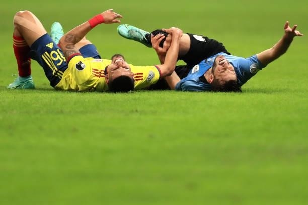 Matias Viña of Uruguay and Daniel Muñoz of Colombia lie on the pitch after suffering an injury during a quarter-final match of Copa America Brazil...
