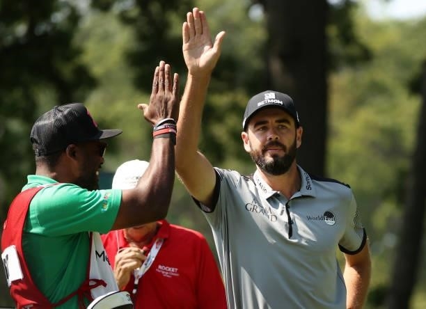Troy Merritt reacts with his caddie Wayne Birch to a hole in one on the 11th green during the third round of the Rocket Mortgage Classic on July 03,...
