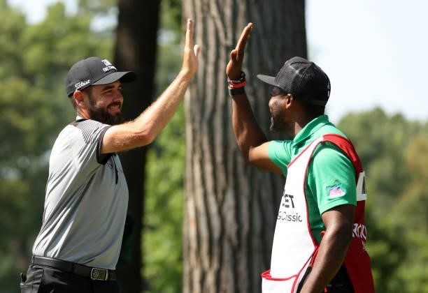 Troy Merritt reacts with his caddie Wayne Birch to a hole in one on the 11th green during the third round of the Rocket Mortgage Classic on July 03,...