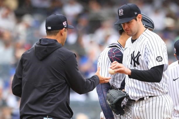 Pitcher Jordan Montgomery of the New York Yankees gives the ball to manager Aaron Boone after being relieved during the fifth inning against the New...