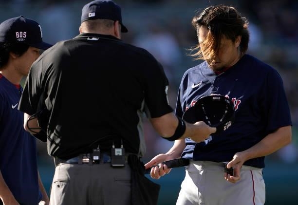 Home plate umpire Dan Bellino checks the hat, pants and glove of pitcher Hirokazu Sawamura of the Boston Red Sox for illegal substance at the end of...