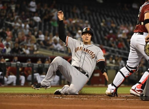 Wilmer Flores of the San Francisco Giants scores on a sacrifice fly hit by LaMonte Wade during the second inning of a game against the Arizona...