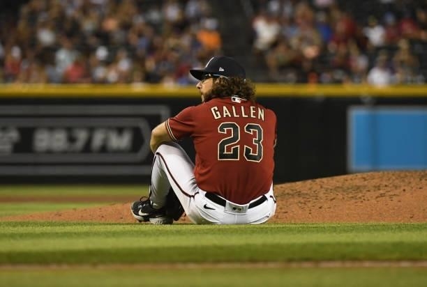 Zac Gallen of the Arizona Diamondbacks sits on the ground in front of the pitchers mound after throwing a pitch during the third inning against the...
