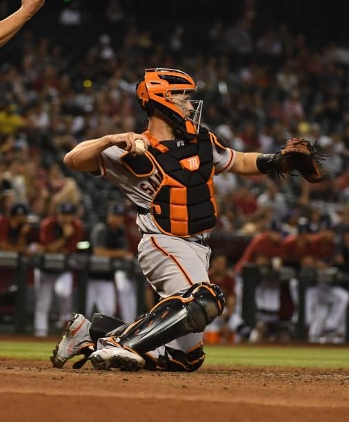 Buster Posey of the San Francisco Giants throws the ball back to the pitchers mound against the Arizona Diamondbacks at Chase Field on July 02, 2021...