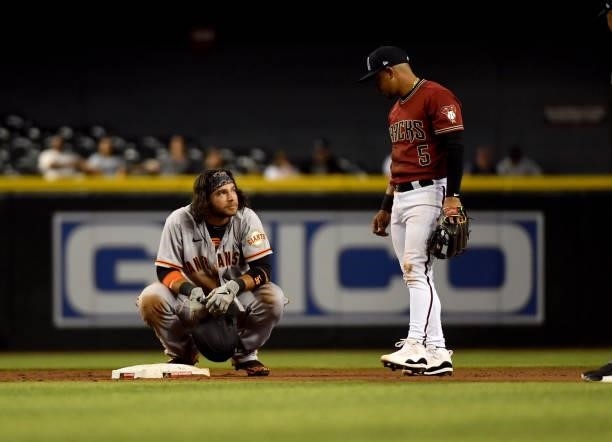 Brandon Crawford of the San Francisco Giants talks with Eduardo Escobar of the Arizona Diamondbacks during a game at Chase Field on July 02, 2021 in...