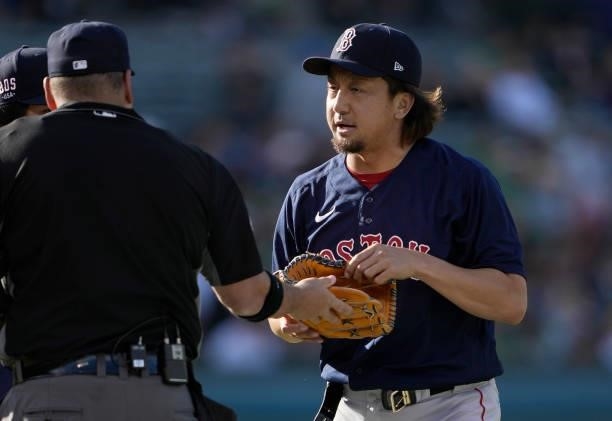 Home plate umpire Dan Bellino checks the hat, pants and glove of pitcher Hirokazu Sawamura of the Boston Red Sox for illegal substance at the end of...