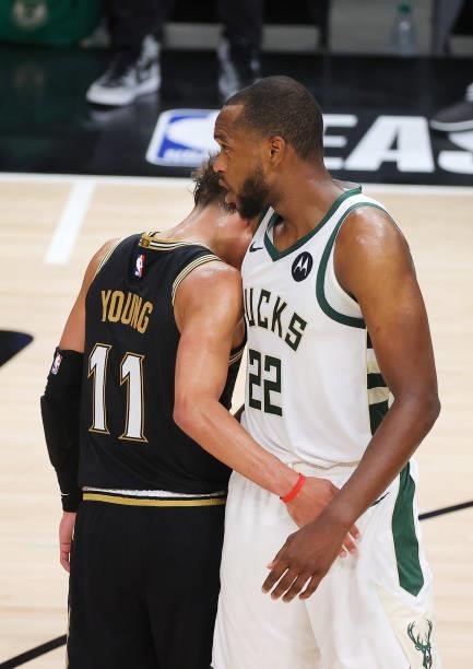 Trae Young of the Atlanta Hawks hugs Khris Middleton of the Milwaukee Bucks as he leaves the court in the final seconds of the team's series loss to...