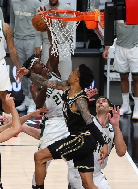 Jrue Holiday of the Milwaukee Bucks goes up for a shot against John Collins of the Atlanta Hawks during the second half in Game Six of the Eastern...