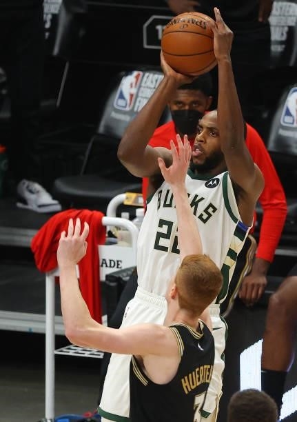 Khris Middleton of the Milwaukee Bucks shoots against Kevin Huerter of the Atlanta Hawks during the first half in Game Six of the Eastern Conference...