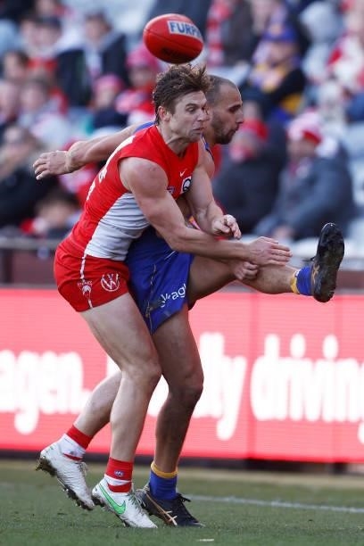 Dom Sheed of the Eagles kicks the ball under pressure from Dane Rampe of the Swans during the round 16 AFL match between Sydney Swans and West Coast...
