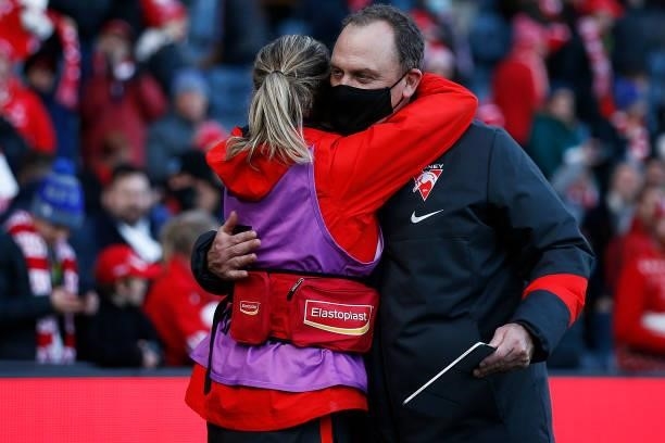 Swans head coach John Longmire hugs a medical staff member as they celebrate victory after the round 16 AFL match between Sydney Swans and West Coast...