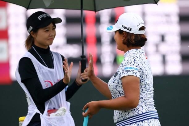 Ai Suzuki of Japan high fives with her caddie after holing out on the 18th green during the final round of the Shiseido Ladies Open at Totsuka...