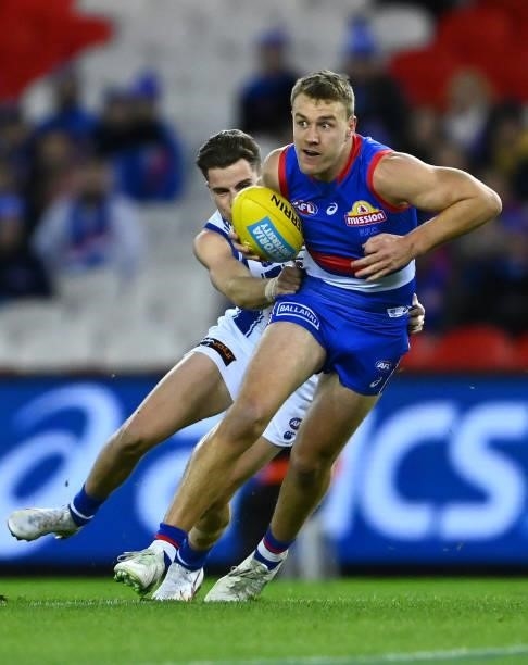 Jackson Macrae of the Bulldogs is tackled by Bailey Scott of the Kangaroos during the round 16 AFL match between Western Bulldogs and North Melbourne...