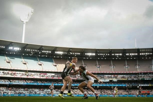 Jordan De Goey of the Magpies evades Ben Long of the Saints during the round 16 AFL match between Collingwood Magpies and St Kilda Saints at...