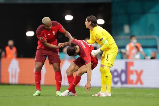 Ricardo Rodriguez of Switzerland is assisted by his teammates goalkeeper Yann Sommer and Manuel Akanji during the UEFA Euro 2020 Championship...