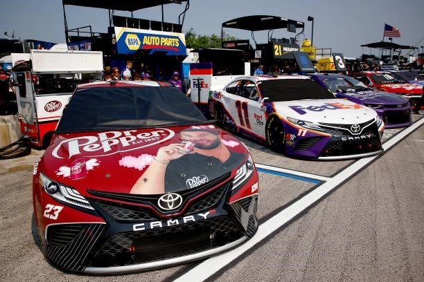 The Dr. Pepper Toyota, driven by Bubba Wallace and the FedEx Freight Toyota, driven by Denny Hamlin sit in the garage area during qualifying for the...
