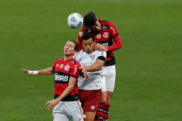 Fred of Fluminense jumps for the ball against Filipe Luis and Gustavo Henrique of Flamengo during a match between Flamengo and Fluminense as part of...