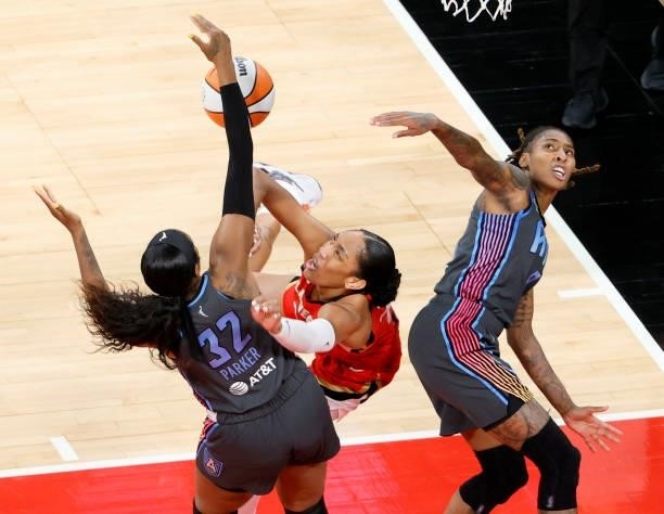Ja Wilson of the Las Vegas Aces is fouled as she drives to the basket against Cheyenne Parker and Crystal Bradford of the Atlanta Dream during their...