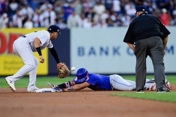 Dominic Smith of the New York Mets slides in safely with a double under the tag of Gio Urshela of the New York Yankees in the fourth inning during...