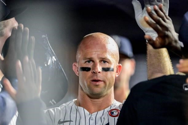 Brett Gardner of the New York Yankees is congratulated in the dugout after scoring a run on a wild pitch against the New York Mets in the fifth...