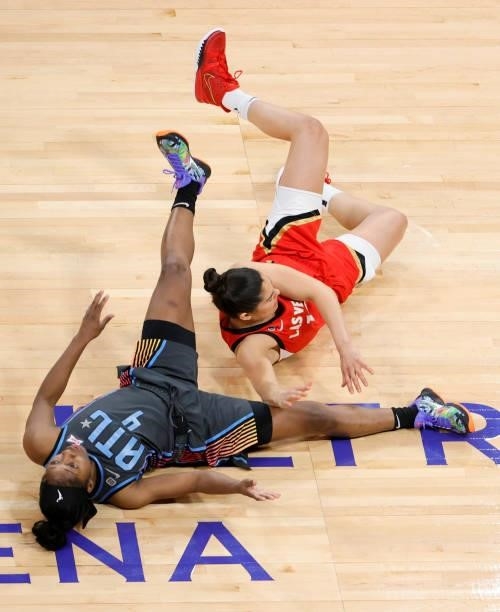 Kelsey Plum of the Las Vegas Aces and Aari McDonald of the Atlanta Dream fall to the floor after colliding during their game at Michelob ULTRA Arena...