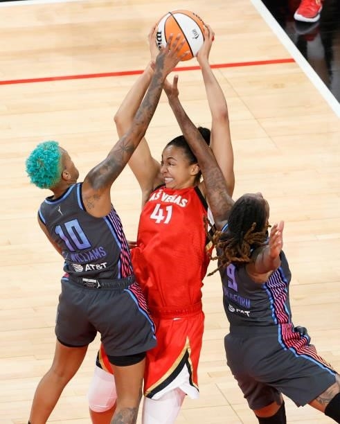 Courtney Williams of the Atlanta Dream fouls Kiah Stokes of the Las Vegas Aces as she grabs a rebound against Williams and Crystal Bradford during...