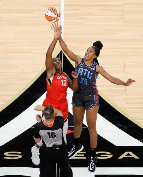 Chelsea Gray of the Las Vegas Aces and Monique Billings of the Atlanta Dream vie for a jump ball thrown by referee Isaac Barnett during their game at...