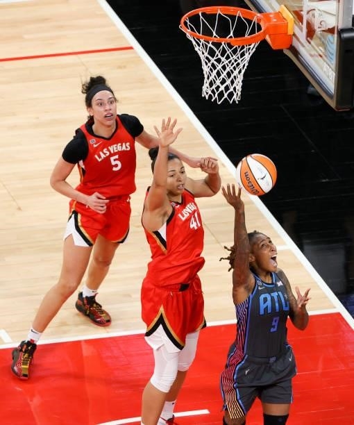 Crystal Bradford of the Atlanta Dream shoots a reverse layup against Kiah Stokes of the Las Vegas Aces as Dearica Hamby of the Aces defends during...
