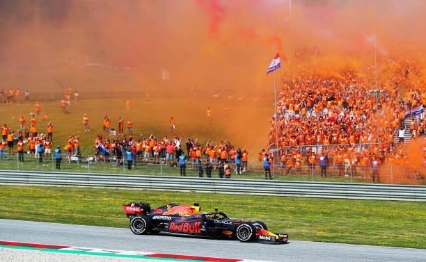 Race winner Max Verstappen of the Netherlands driving the Red Bull Racing RB16B Honda past a grandstand full of his fans celebrating during the F1...