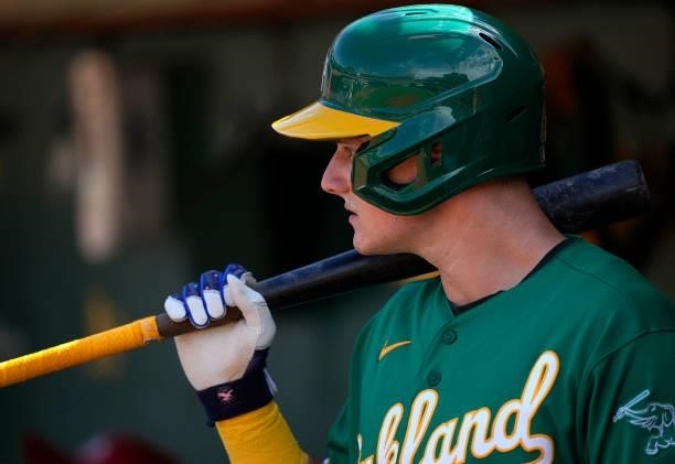 Matt Chapman of the Oakland Athletics holding his bat over his shoulder looks on from the dugout against the Boston Red Sox in the bottom of the...