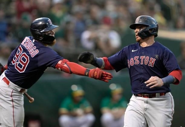 Christian Vazquez of the Boston Red Sox is congratulated by Alex Verdugo after Vazquez scored against the Oakland Athletics in the top of the 12th...