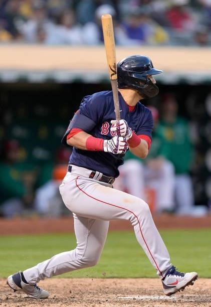 Marwin Gonzalez of the Boston Red Sox hits an RBI single scoring Rafael Devers against the Oakland Athletics in the top of the 12th inning at...