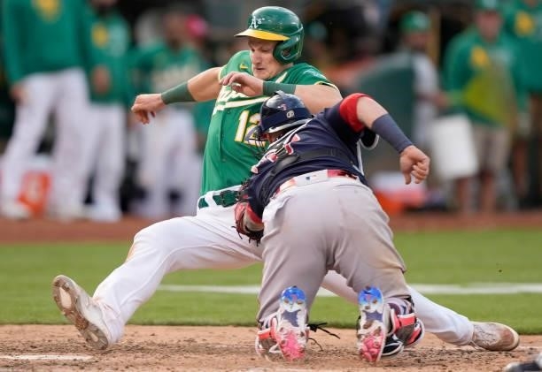 Christian Vazquez of the Boston Red Sox at home plate tags out Sean Murphy of the Oakland Athletics in the bottom of the tenth inning at RingCentral...