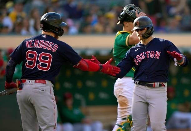 Enrique Hernandez of the Boston Red Sox is congratulated by Alex Verdugo after Hernandez hit a solo home run against the Oakland Athletics in the top...
