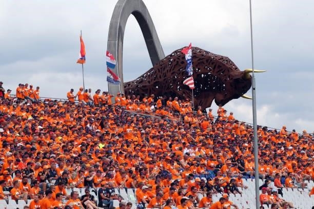 Supporters of Red Bull's Dutch driver Max Verstappen cheer from the stands near the large-scale jumping bull sculpture during the F1 Grand Prix of...