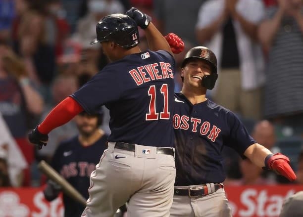 Rafael Devers of the Boston Red Sox celebrates a two-run home run with Enrique Hernandez against the Los Angeles Angels in the fourth inning at Angel...