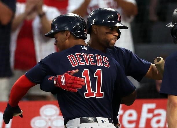 Rafael Devers of the Boston Red Sox celebrates a two-run home run with Xander Bogaerts against the Los Angeles Angels in the fourth inning at Angel...
