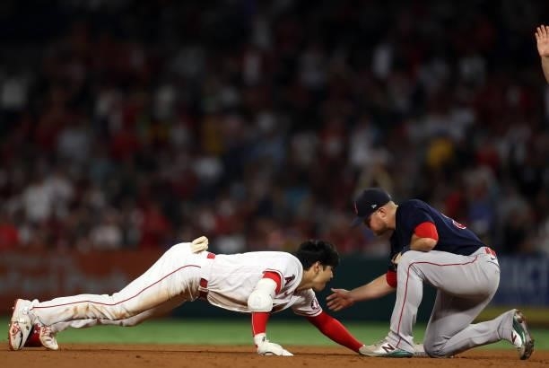 Shohei Ohtani of the Los Angeles Angels is safe against Christian Arroyo of the Boston Red Sox in the fifth inning at Angel Stadium of Anaheim on...