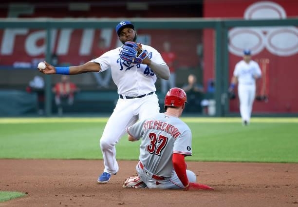 Hanser Alberto of the Kansas City Royals throws toward first in a double play attempt as Tyler Stephenson of the Cincinnati Reds slides into second...