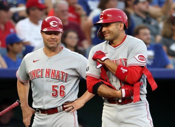 Joey Votto of the Cincinnati Reds reacts with third base coach J.R. House after hitting a 2-RBI triple during the 3rd inning of the game against the...
