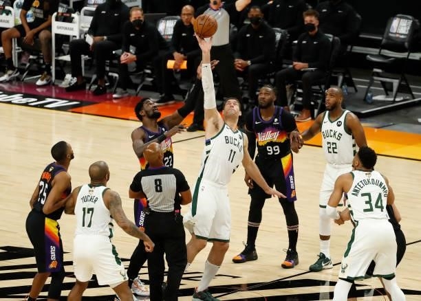 Brook Lopez of the Milwaukee Bucks and Deandre Ayton of the Phoenix Suns go up for the tip during the first quarter in Game One of the NBA Finals at...