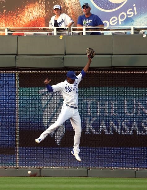 Michael A. Taylor of the Kansas City Royals leaps but cannot catch a fly ball off the bat of Joey Votto of the Cincinnati Reds that resulted in a...