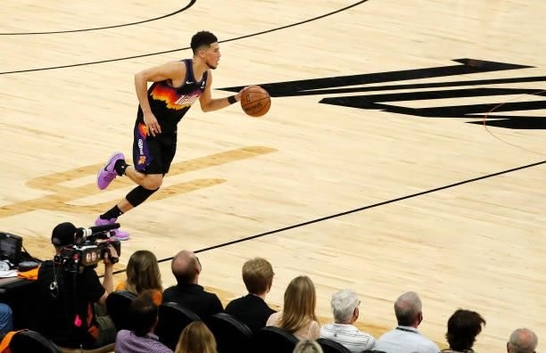Devin Booker of the Phoenix Suns brings the ball up court against the Milwaukee Bucks during the first quarter in Game One of the NBA Finals at...