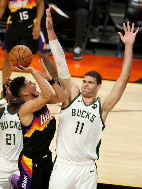 Devin Booker of the Phoenix Suns goes up for a shot against Brook Lopez of the Milwaukee Bucks during the first quarter in Game One of the NBA Finals...